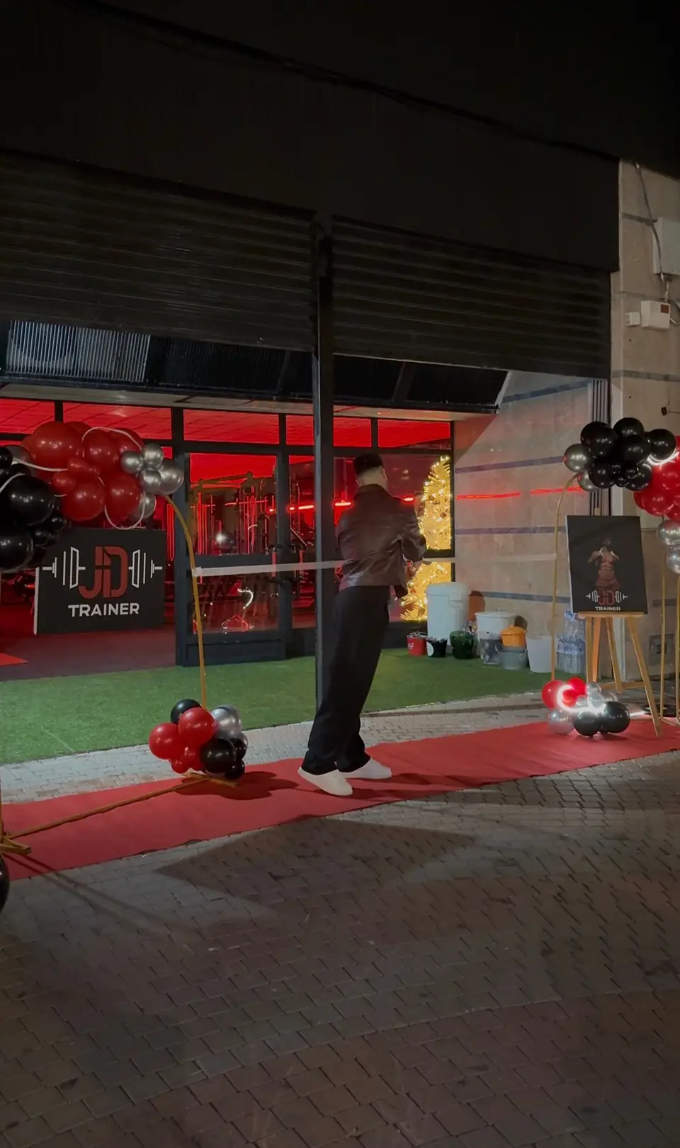 Entrada de JD Trainer decorada con globos rojos y negros el día de la inauguración